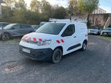 La camionnette est garée sur le parking, à côté d'autres voitures.