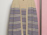 un cardigan rayé beige et bleu suspendu à un cintre
