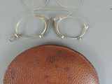 a pair of glasses and a leather case on a table