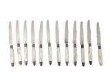 six knives are lined up in a row on a white surface