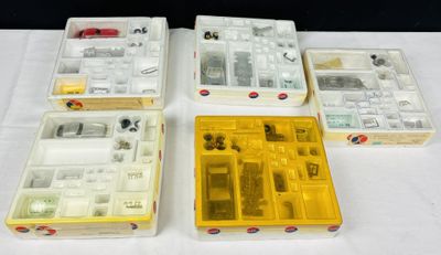 quatre boîtes contenant un assortiment de composants électroniques, posées sur une table