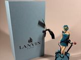 a figurine of a woman riding a bike next to a blue box