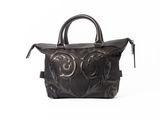 sac à main en cuir noir sur fond blanc, avec un fond blanc