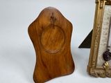 a small wooden clock next to a picture frame on a table