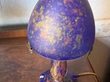 a purple lamp that is sitting on a wooden table