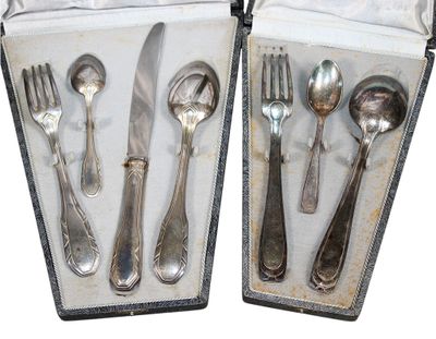 deux sets d'argenterie dans un coffret sur une table