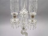 a glass candelab with three candles inside of it