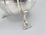 a silver bowl with a handle on a table