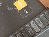 a close up of a laptop with a yellow button on it