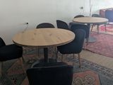 tables and chairs in a room with a rug on the floor