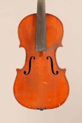un vieux violon posé sur une surface blanche