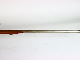 an old rifle is laying on a white surface with a wooden handle