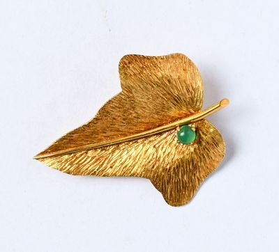 une broche en feuille d'or sertie d'une pierre verte