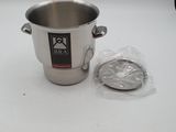 une casserole en argent et un sac en plastique posés sur une table blanche