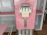 a pink refrigerator sitting in a room with a pink table and chairs