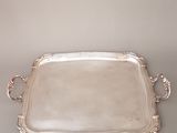 un plateau ancien en argent avec des poignées et des poignées sur une table