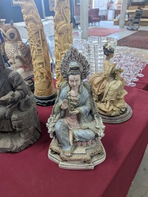 many statues on a red table with a red table cloth