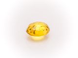 a yellow sapphire stone on a white background