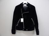 a black jacket hanging on a hanger on a white wall