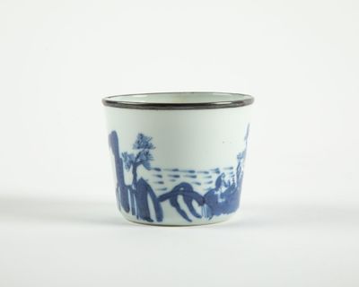 une tasse bleue et blanche sur laquelle sont représentées des personnes