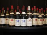 bottles of wine lined up on a shelf in a room