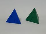 two triangulars with holes in each of them on a white surface
