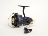 a black spinning reel with a gold handle on a white background