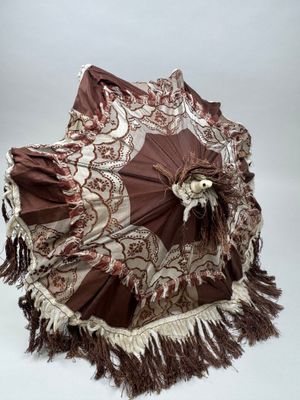 un parapluie marron et blanc orné de franges