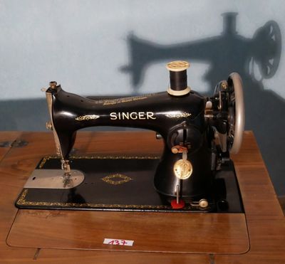 une machine à coudre noire posée sur une table en bois