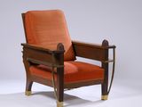 un fauteuil rembourré de couleur orange, avec une structure en bois et des pieds en métal
