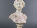 a white marble bust of a woman on a pedestal