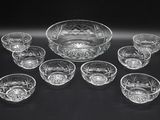an assortment of glass bowls and bowls sitting on a table