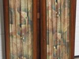 two wooden doors with curtains on them in front of a brick wall