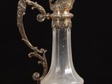 a glass vase with a bird on it on a table