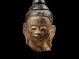 une tête de Bouddha sculptée sur fond noir
