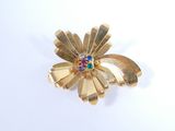 une broche en forme de fleur en or, ornée de pierres multicolores