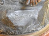 a bronze statue of a person holding a dog on a rock