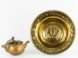 une théière en or et une assiette en or sur fond blanc