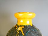 un vase jaune orné d'un motif noir et bleu