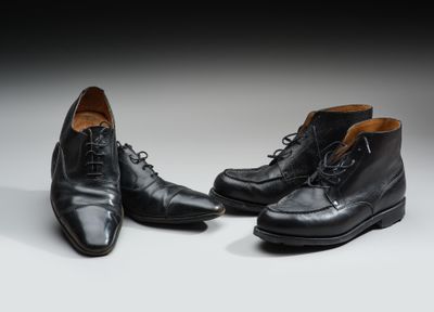 une paire de chaussures en cuir noir posée sur une surface blanche