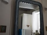 un miroir sur le mur au-dessus d'un lavabo dans une salle de bains