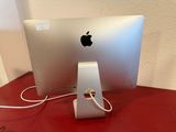 an apple computer sitting on a desk with a charger attached to it