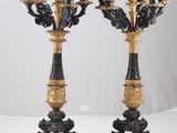 pair of black and gold candelabs with a lion head on top