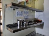 many pots and pans on the shelf in the kitchen