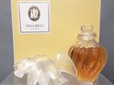a bottle of perfume next to a box on a table