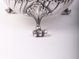 an antique silver plated sugar dish with ornate design on a white surface