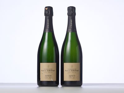 deux bouteilles de champagne posées l'une à côté de l'autre sur une table