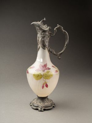 un vase blanc avec des fleurs roses sur une table