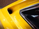 a close up of a yellow car with a person in the window