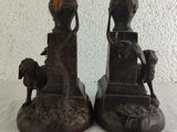 two statues of a woman and a dog on a table
